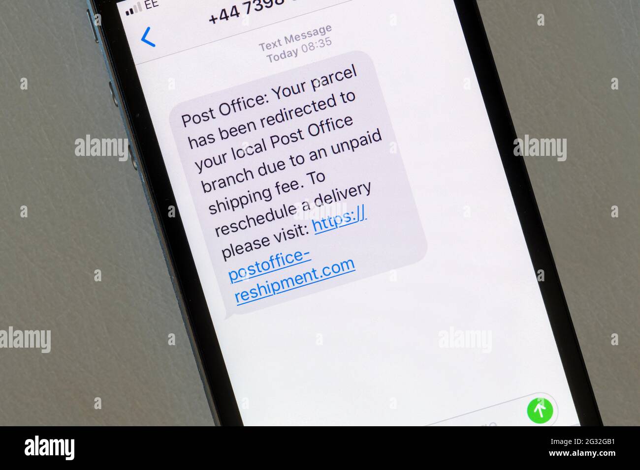 Eine auf einem iphone angezeigte Betrugsmeldung, die vorgibt, von der Post zu kommen, um eine Paketzustellung zu verschieben. Stockfoto