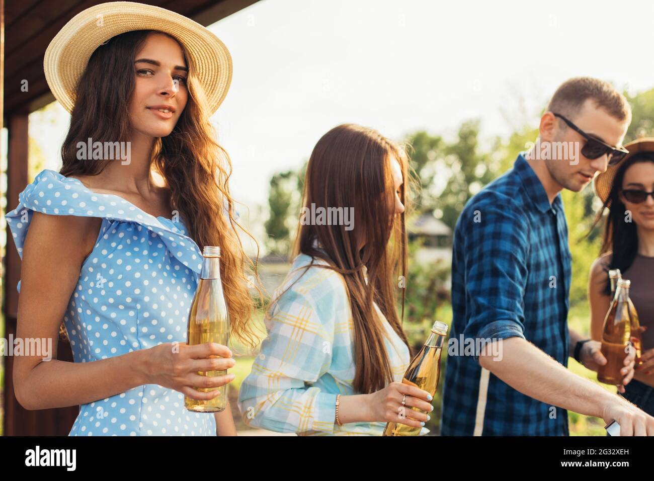 Junge Freunde haben Spaß, trinken Getränke, glückliche Menschen zusammen machen Grill Gemüse und Fleisch auf dem Grill, auf einem Picknick in der Natur, im Freien Stockfoto