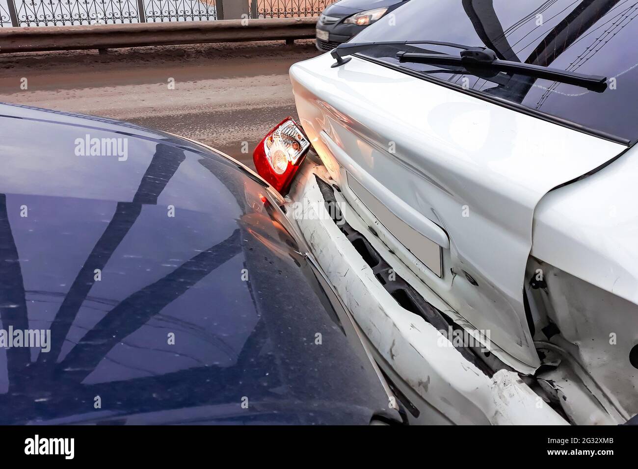 Unfall auf der Straße. Beschädigte Autos nach einer Kollision. Fragment eines gebrochenen Stoßfängers. Stockfoto