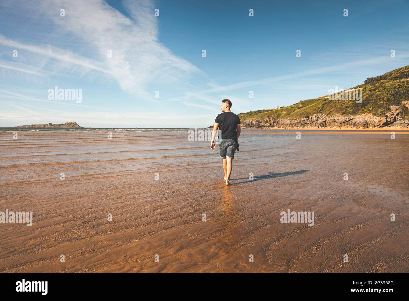 Junger Kaukasier, der am Strand läuft Stockfoto