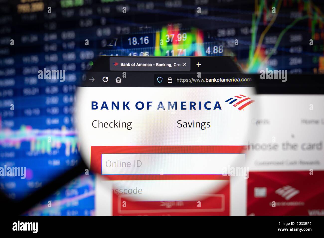 Firmenlogo der Bank of America auf einer Website mit unscharfen Börsenentwicklungen im Hintergrund, die auf einem Computerbildschirm zu sehen sind Stockfoto