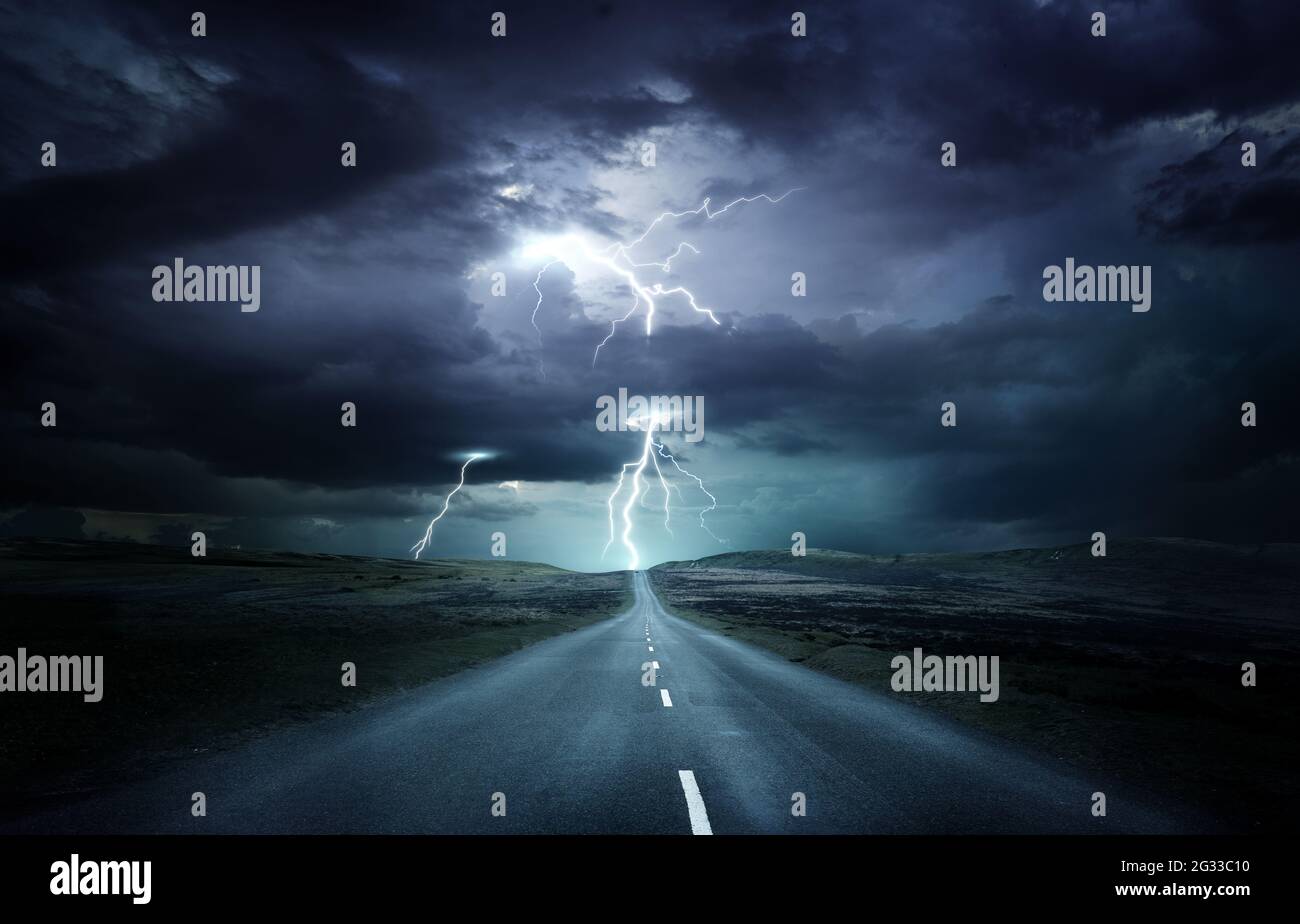 Extreme Wetterbedingungen. Eine leere Landschaft mit einer Straße, die in ein starkes Gewitter mit Blitzeinschlägen führt. Fotokomposition. Stockfoto