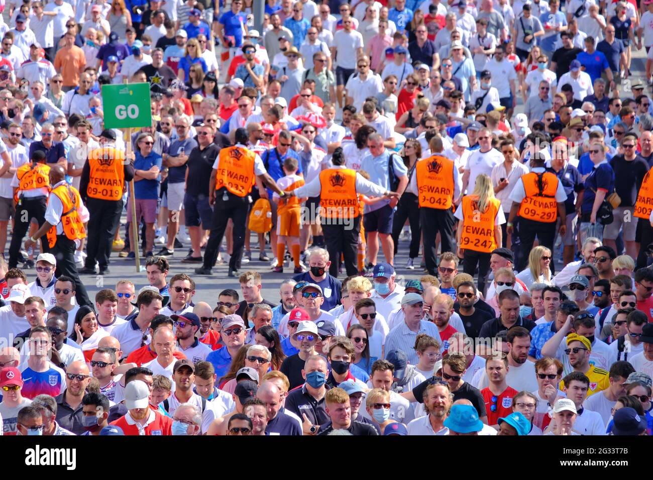 Stewards bilden eine menschliche Barriere, um Menschenmengen zu regulieren, die nach dem Gruppenspiel „EM 2020 England gegen Kroatien“ in die U-Bahn-Station Wmebley Park eindringen. Stockfoto