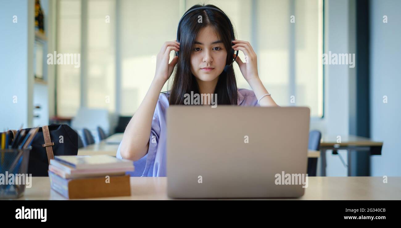 Ein Mädchen übt vor dem Online-Kurs per Video die Grundkursübungen auf dem Laptop. Soziale Distanzierung.Bleib zu Hause. Neuer Normalwert. Covid-19 Coronavirus-Konzept. Stockfoto