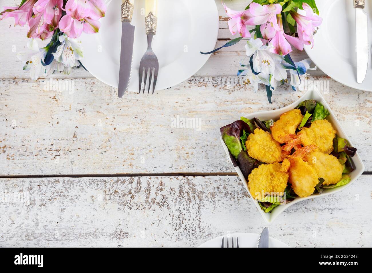 Frittierte panierte Garnelen mit Salat und Tischset. Stockfoto