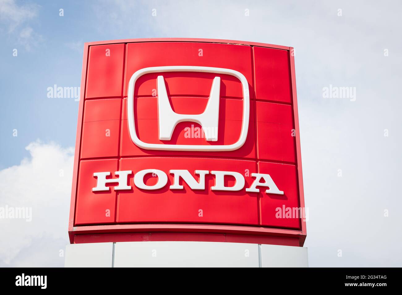 Das Honda-Logo ist auf einer Plakatwand vor einem bewölkten Himmel zu sehen. Stockfoto