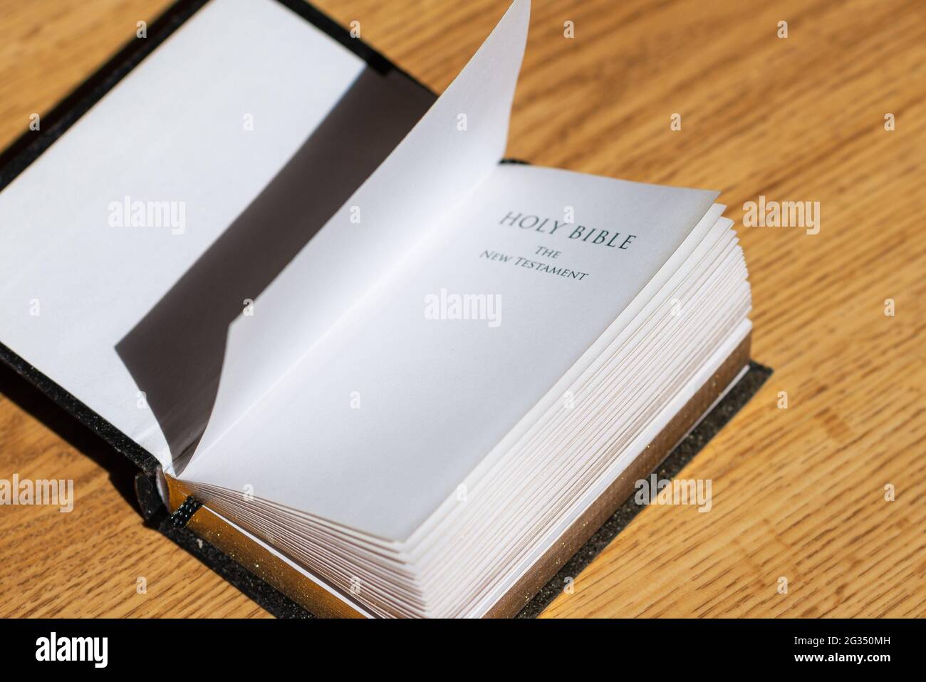 Öffnen Sie die Heilige Bibel auf einem braunen Holztisch.Öffnen Sie die Heilige Bibel von oben.Religiöses Konzept. Stockfoto