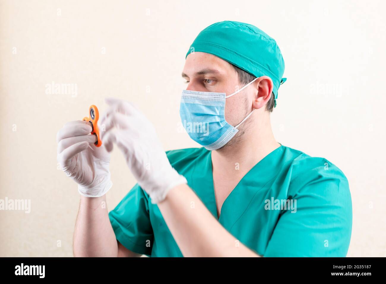 Ein Arzt in einer Maske und Handschuhen, mit einem Spinner in den Händen. Stockfoto
