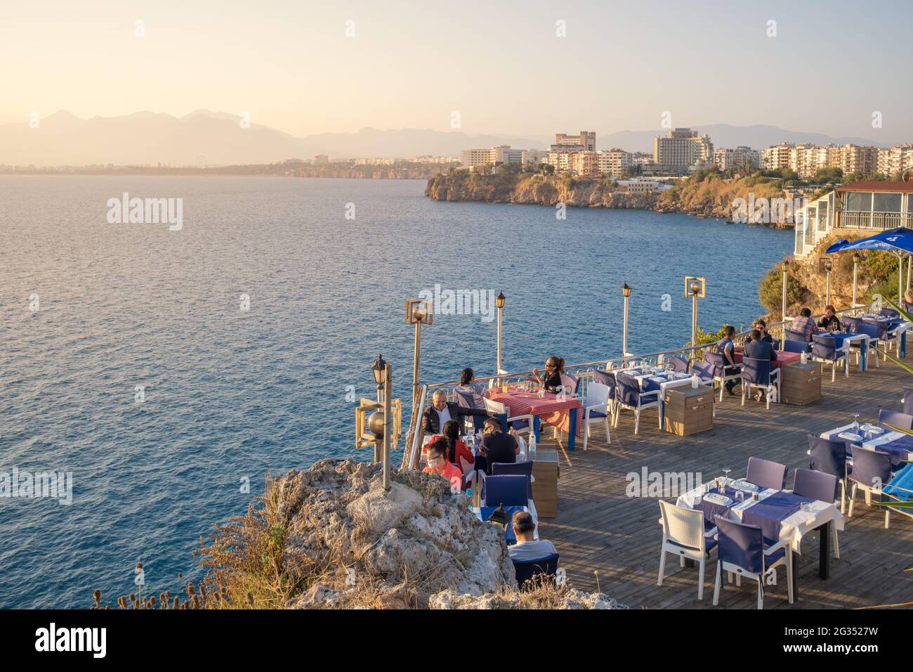 Restaurant am Rande der Klippe am Mittelmeer während des Sonnenuntergangs in Antalya, Türkei Stockfoto