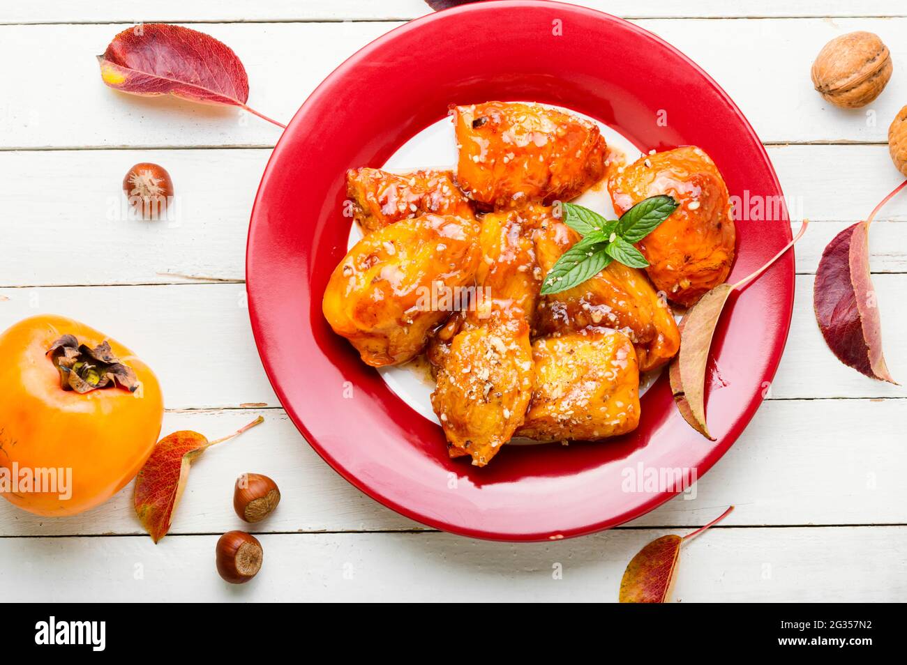 Stücke von karamellisiertem Persimmon.Delicious Caramel Persimmon auf dem Teller Stockfoto