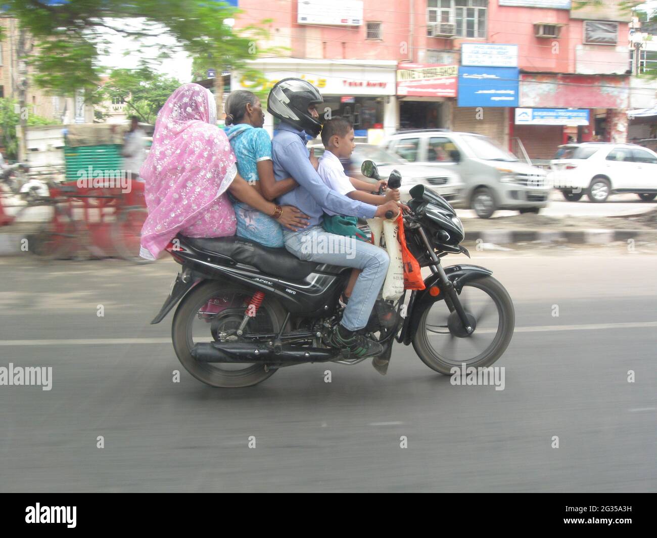 Neu Delhi, Indien - 26. Juni 2013: Indische vierköpfige Familie fährt auf einem Motorrad Stockfoto