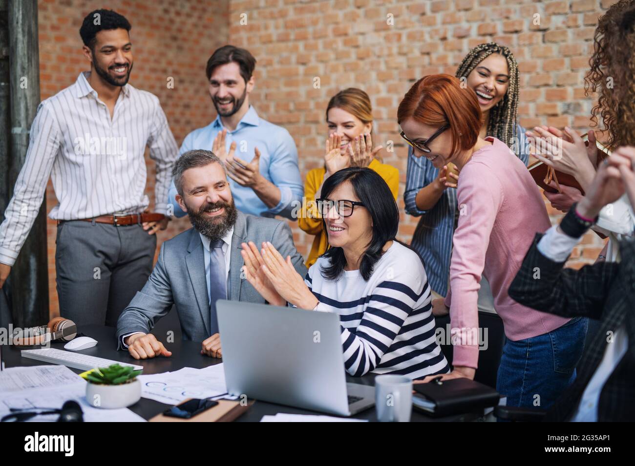 Gruppe von Unternehmern, die im Büro an einem Projekt arbeiten und einen erfolgreichen Vertrag feiern. Stockfoto