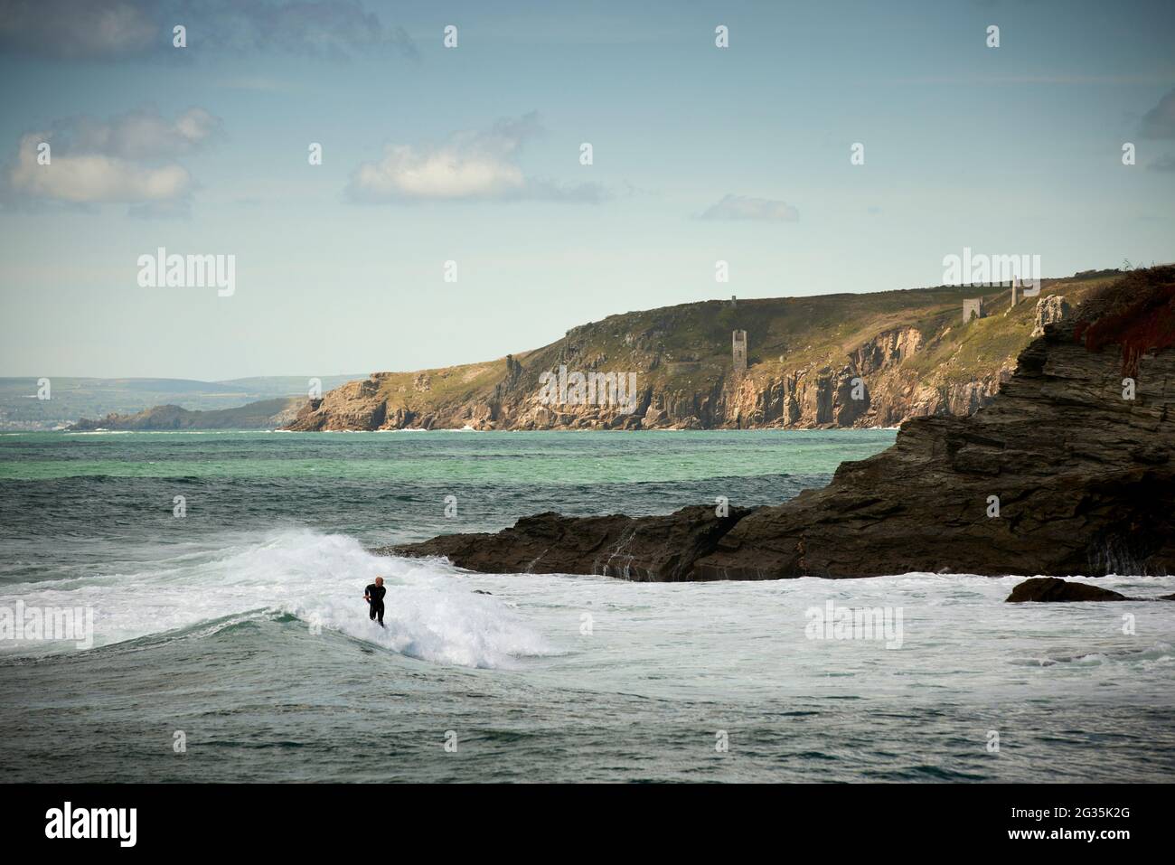 Das kornische Touristenziel Porthleven, Cornwall, England, stellte Surfer an der Küste vor, die Wellen reiten Stockfoto