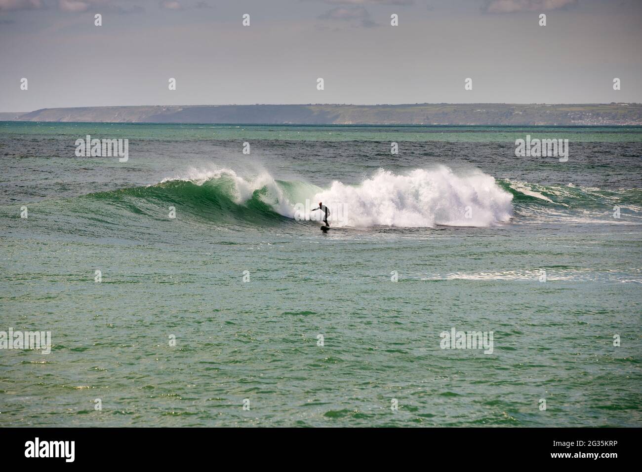 Das kornische Touristenziel Porthleven, Cornwall, England, stellte Surfer an der Küste vor, die Wellen reiten Stockfoto