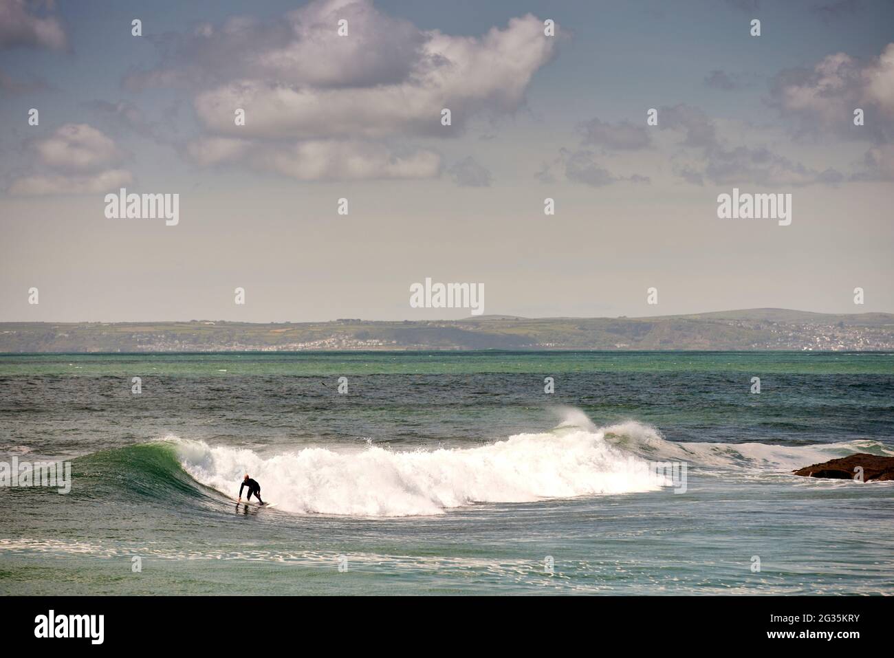 Das kornische Touristenziel Porthleven, Cornwall, England, stellte Surfer an der Küste vor, die Wellen reiten Stockfoto