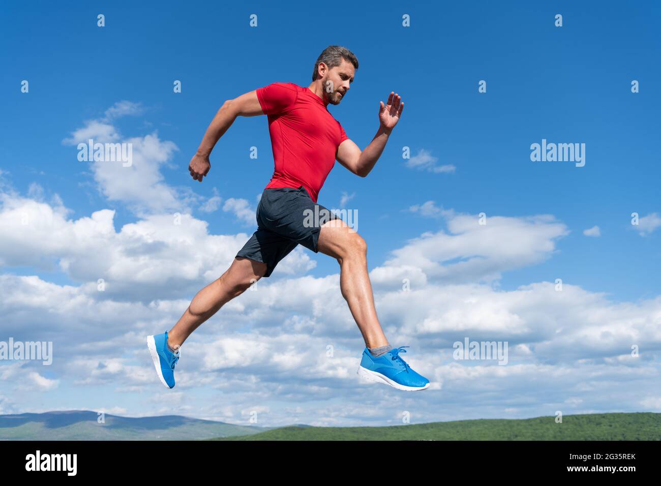 Sportler Mann Läufer laufen zum Erfolg oder springen hoch auf Himmel Hintergrund, Sport Stockfoto