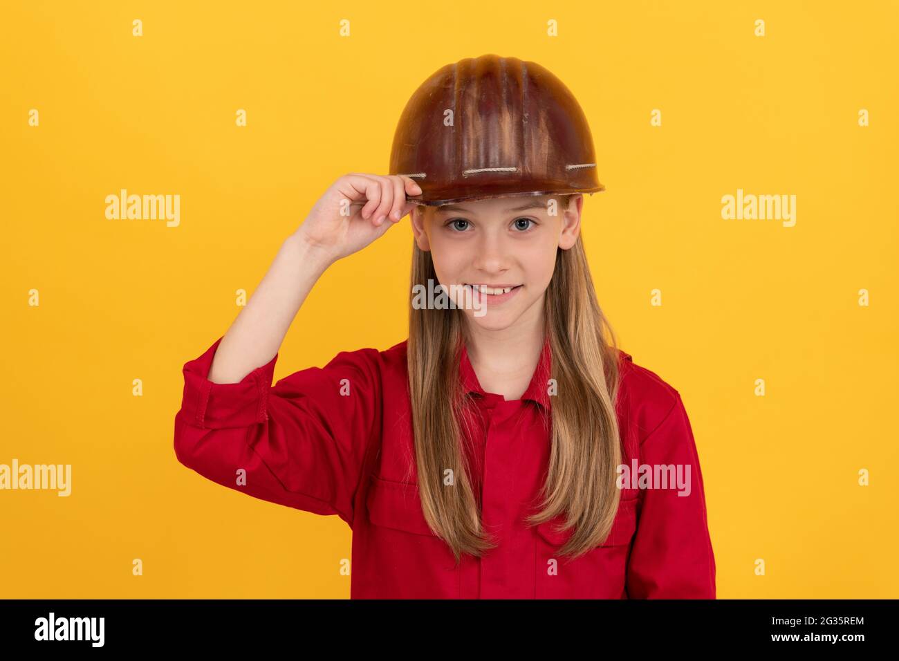 Zukünftige Karriere von Teenager-Mädchen in Helm-Builder mit Konzept der kindlichen Entwicklung, glücklichen Tag der Arbeit Stockfoto