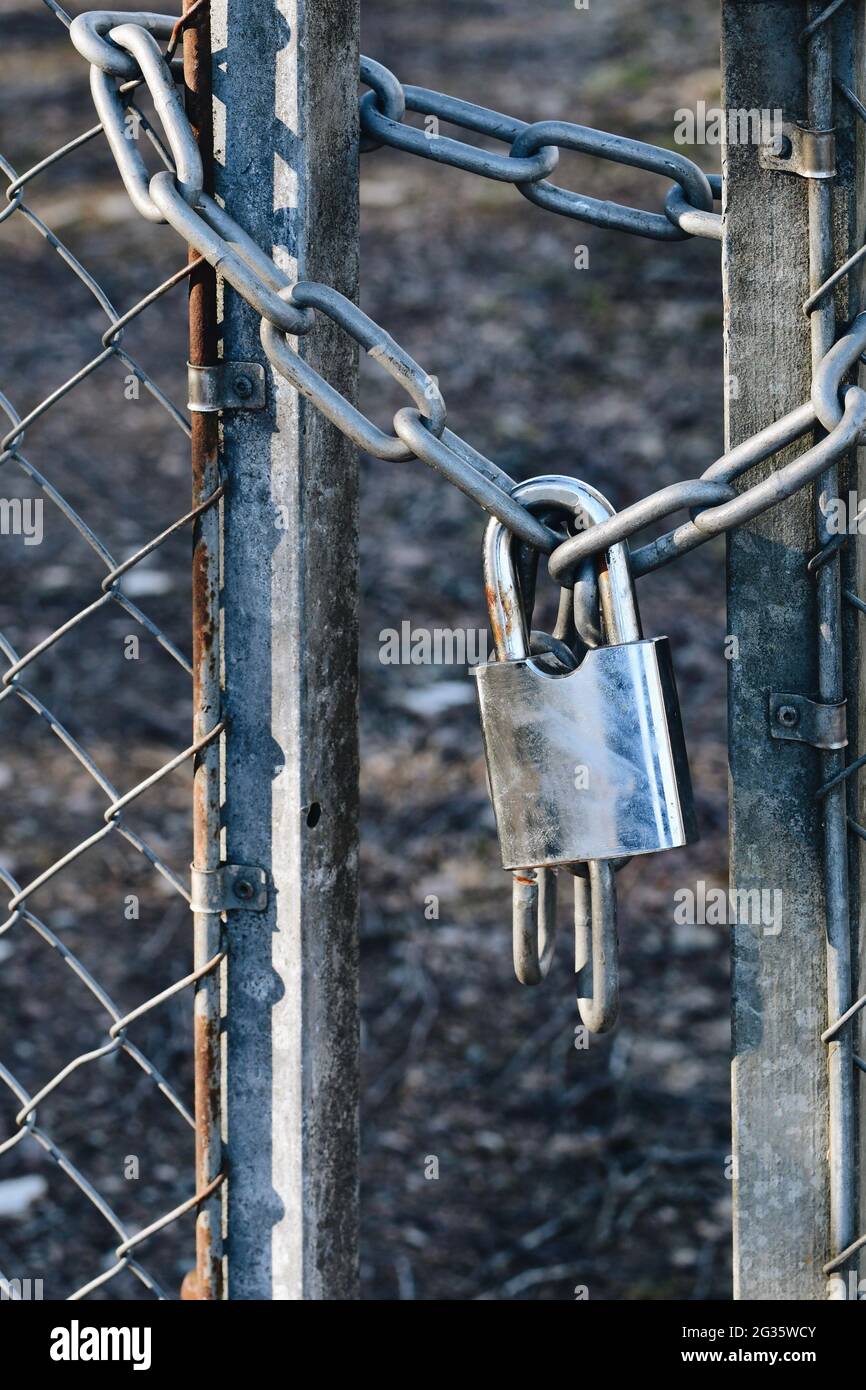 Foto eines Metallvorhängeschlosses an einem Tor und Zaun Stockfoto