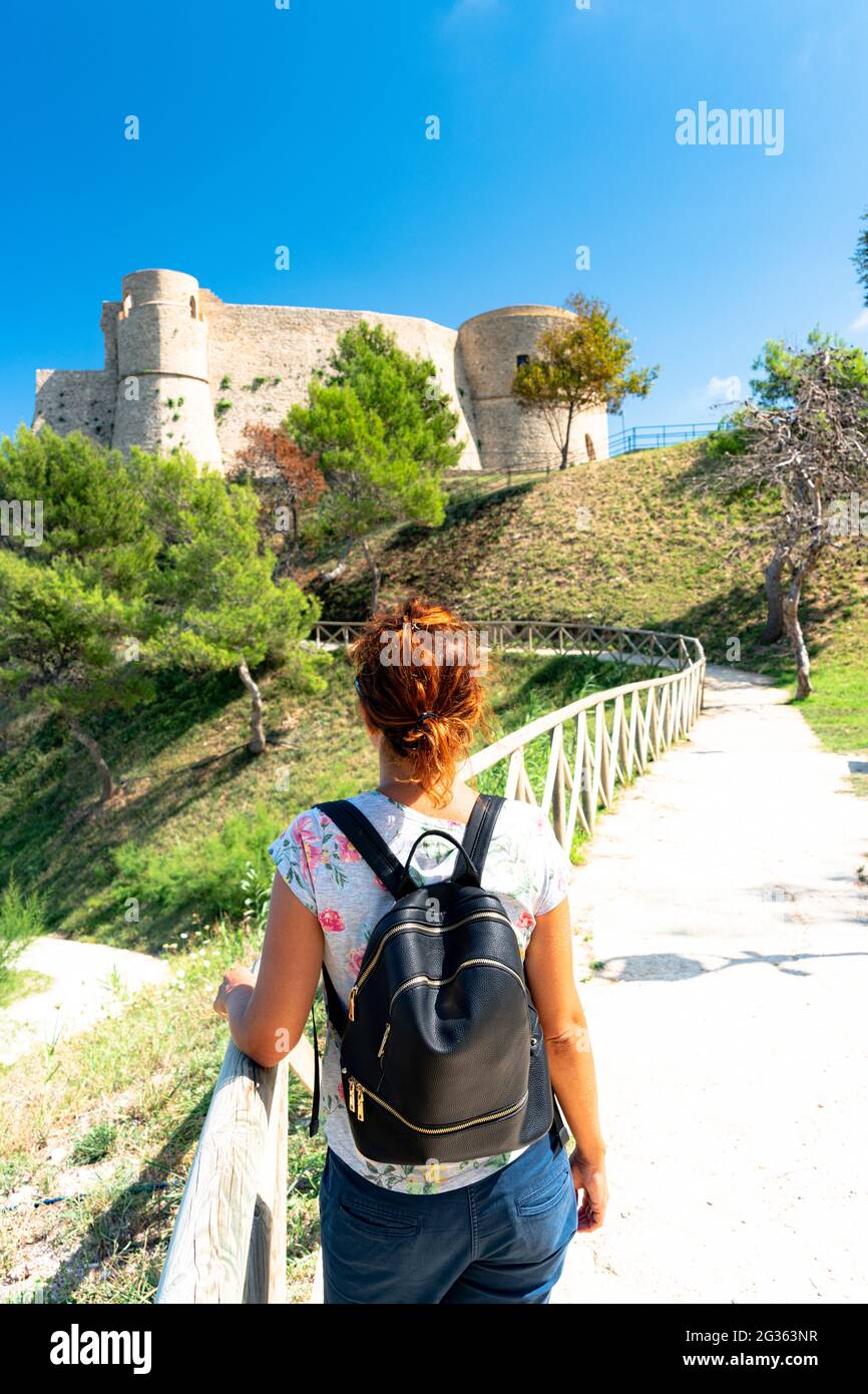 Rückansicht der Wanderfrau, die den mittelalterlichen Komplex von Castello Aragonese, Ortona, Provinz Chieti, Abruzzen, Italien, betrachtet Stockfoto