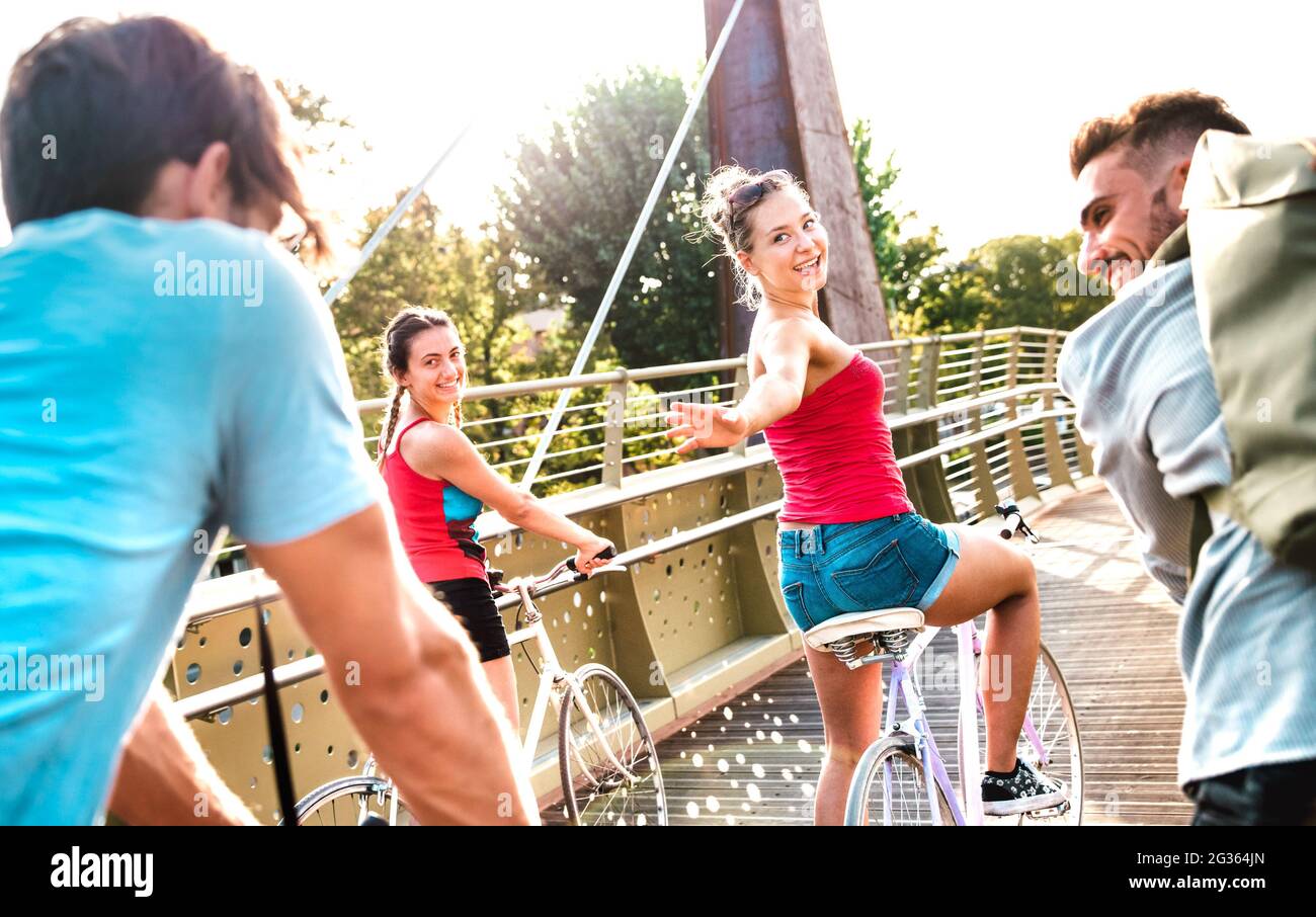 Glückliche Freunde, die Spaß haben, Fahrrad im Stadtpark zu fahren - Freundschaftsleben-Konzept mit jungen Jahrtausenden Studenten Radfahren zusammen an der Universität Stockfoto