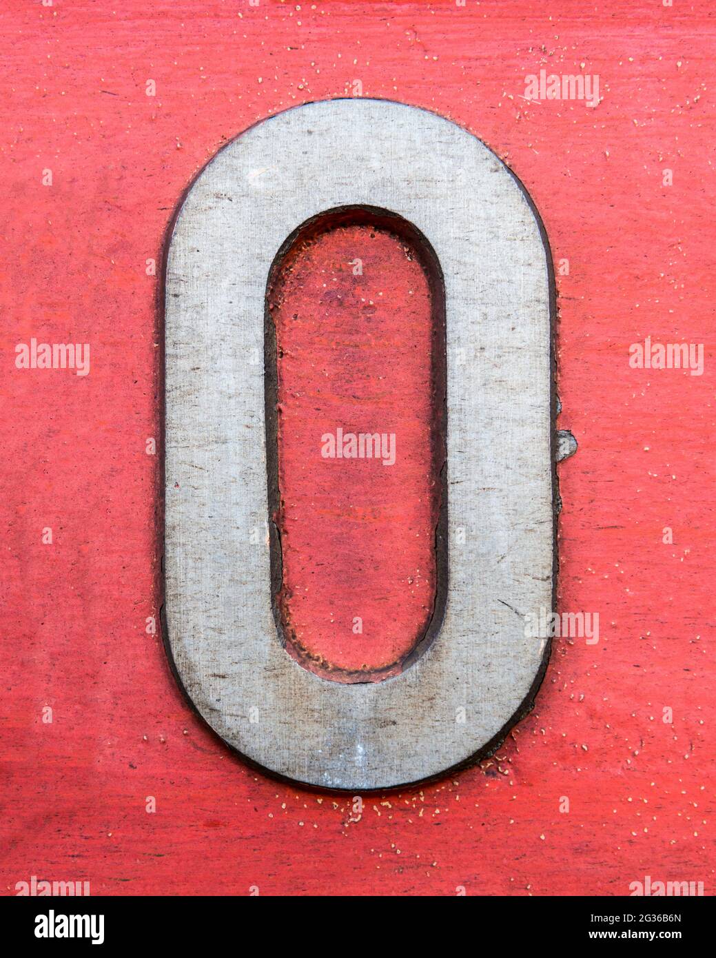 Nummer Null aus Metall auf rot lackiertem Hintergrund Stockfoto