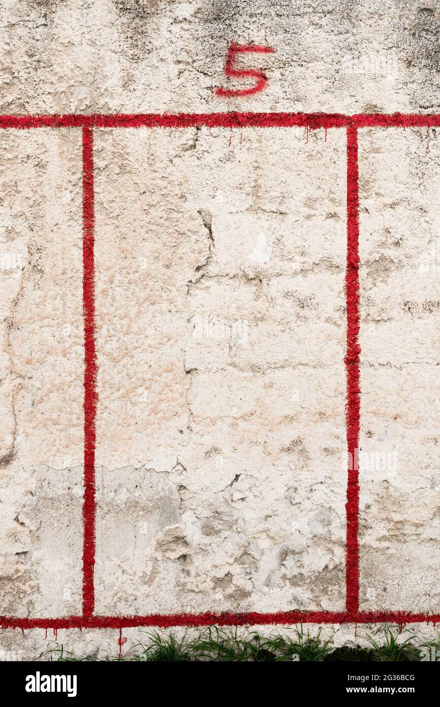 Rote Zahl 5 und roter Rahmen auf verwitterte Wand gesprüht Stockfoto