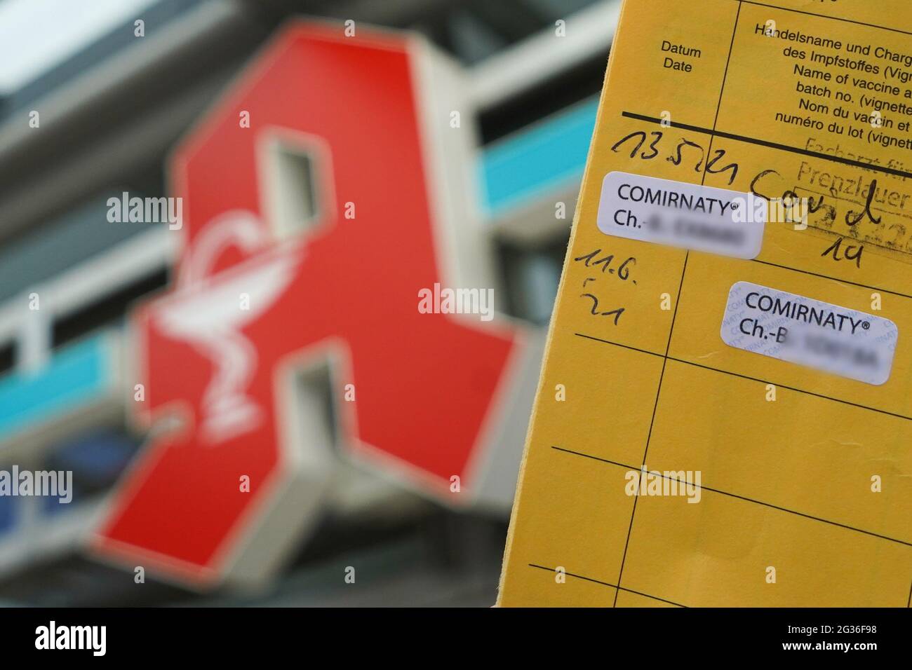 14. Juni 2021, Berlin: Vor dem Logo einer Apotheke in Pankow wird ein Impfpass festgehalten, der zwei Corona-Impfungen mit Comirnaty dokumentiert (Abbildung). Bürger, die zweimal gegen Corona geimpft wurden, können sich ab heute einen digitalen Impfpass in einzelnen Apotheken ausstellen lassen. Der digitale Impfpass ist eine zusätzliche Möglichkeit, Corona-Impfungen zu dokumentieren. Es ist ab heute in einzelnen Apotheken erhältlich. Foto: Jörg Carstensen/dpa - ACHTUNG: Die Chargennummern des Impfstoffes wurden aus rechtlichen Gründen verpixelt Stockfoto