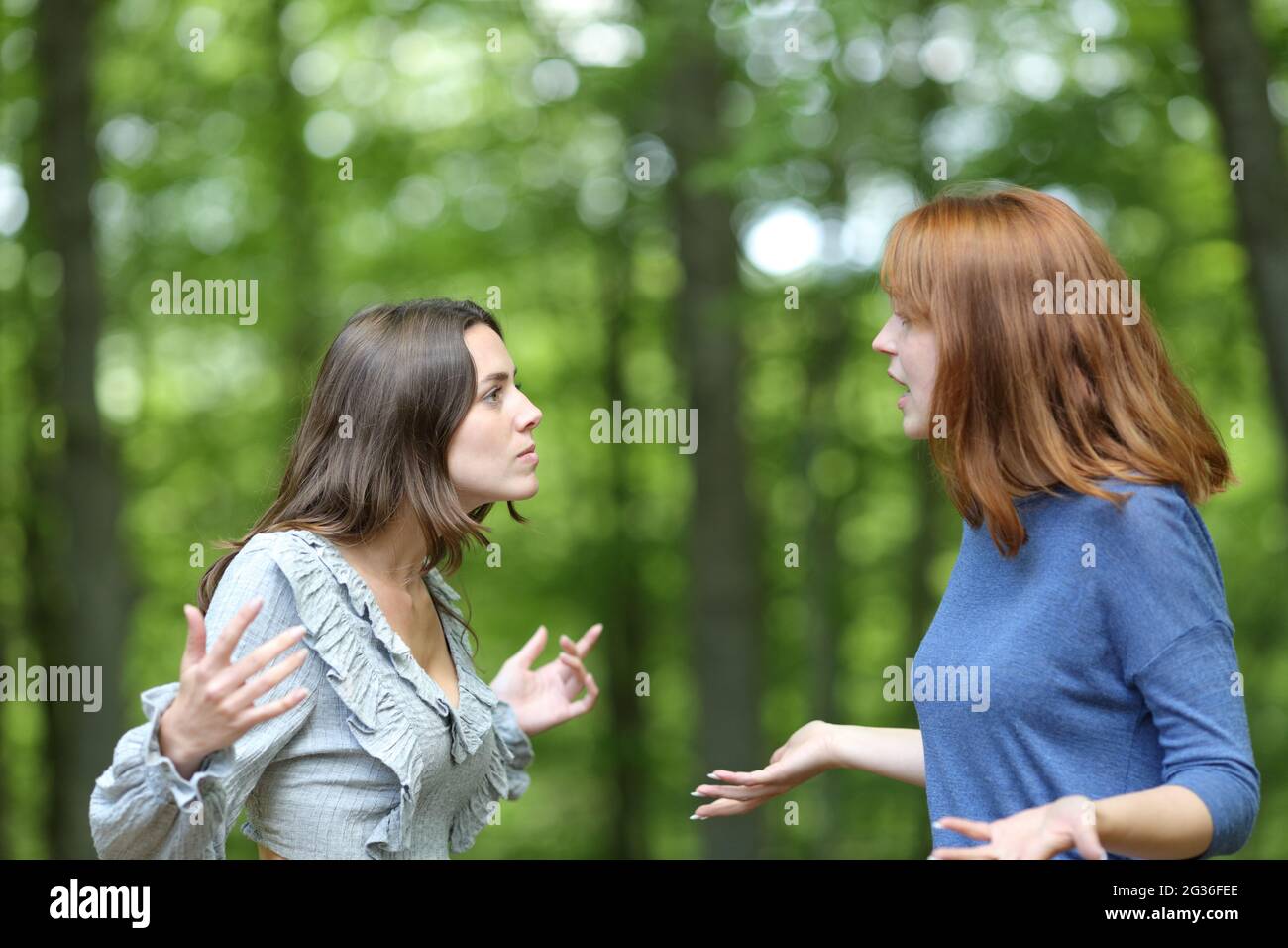 Zwei wütende Frauen, die in einem Wald umherragen Stockfoto