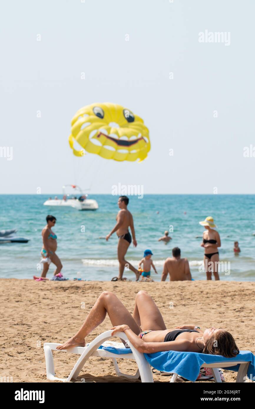 Antalya, Türkei-11. September 2017: Junge Frau sonnt sich an einem heißen Sommertag in Antalya auf der Sonnenliege am Strand. Menschen, die Aktivitäten durchführen. Stockfoto