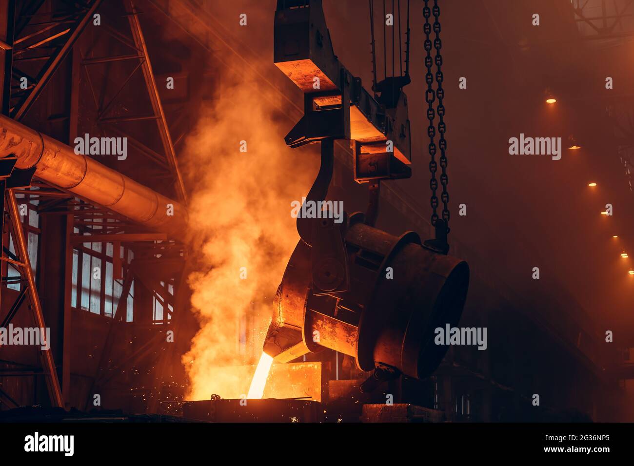 Gießerei. Metallgussverfahren. Geschmolzenes Eisen, das mit Funken und Rauch in die metallurgische Anlage strömt. Stockfoto