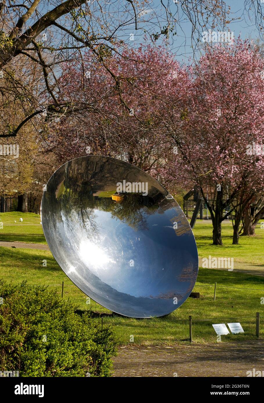 Skulpturengarten mit einem Kunstwerk aus poliertem Stahl im Frühjahr, Deutschland, Nordrhein-Westfalen, Köln Stockfoto