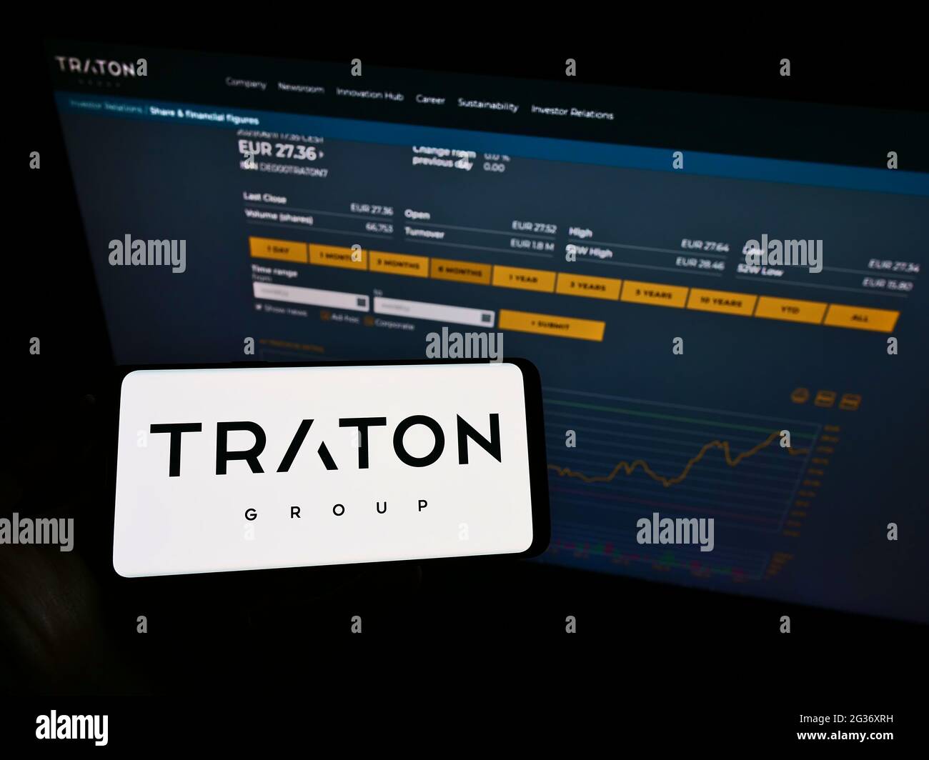 Person, die Smartphone mit Logo des deutschen Nutzfahrzeugherstellers TRATON SE auf dem Bildschirm vor der Website hält. Konzentrieren Sie sich auf die Telefonanzeige. Stockfoto
