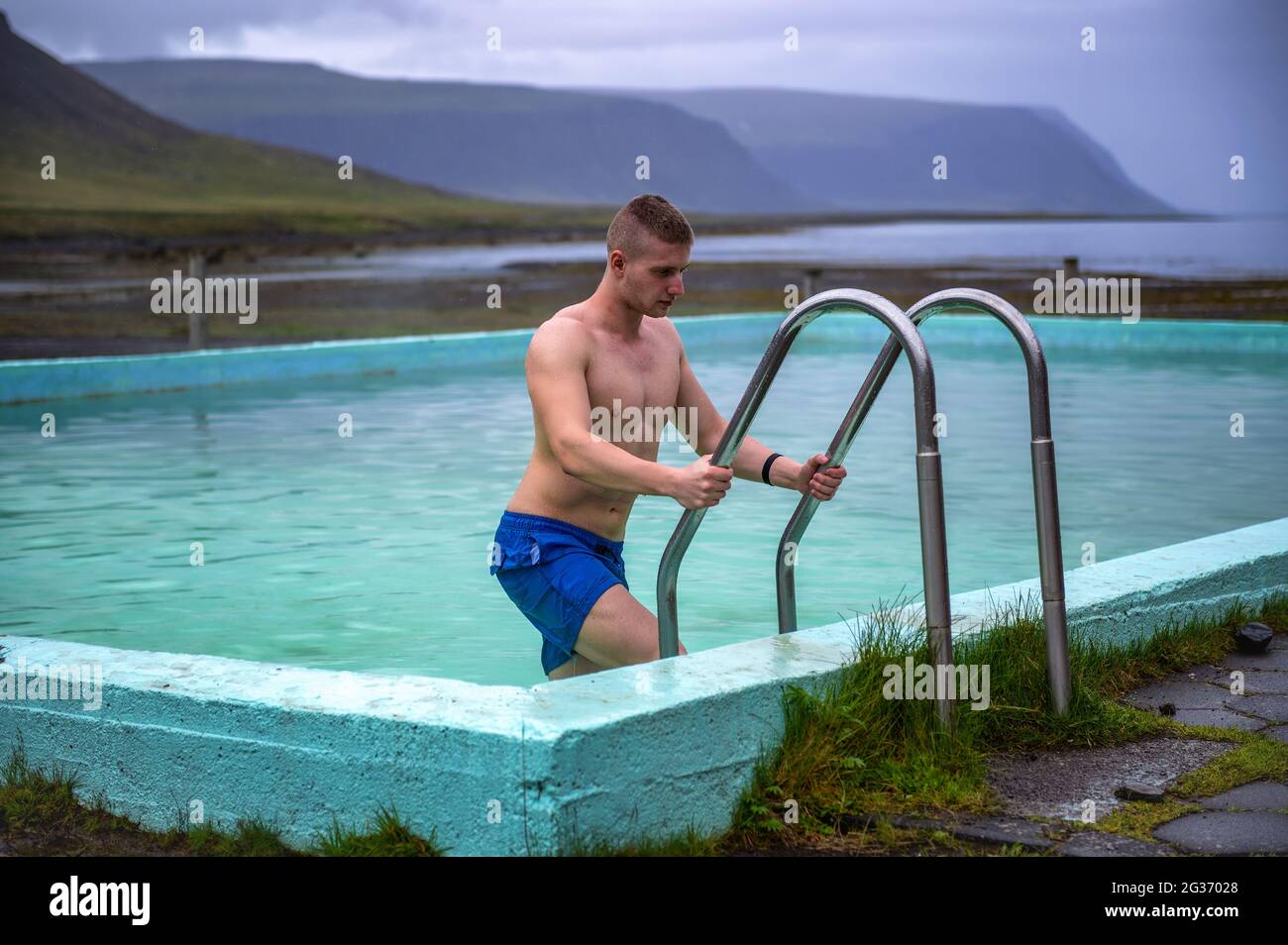 Boy steigt aus dem Reykjafjardarlaug Hot Pool in den Westfjorden, Island Stockfoto