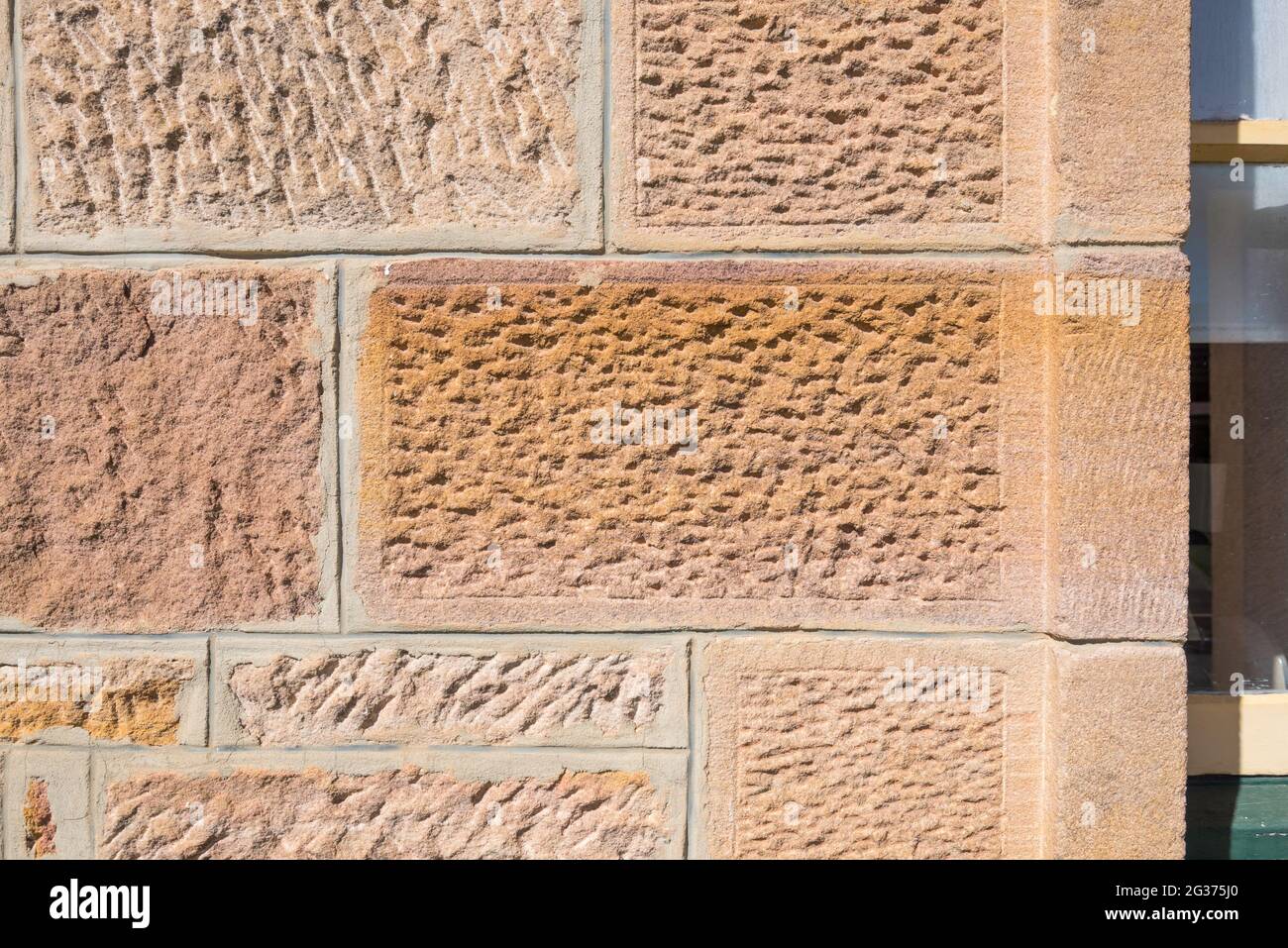 Nahaufnahme einer handgeschnittenen Sandsteinwand aus den späten 1830er Jahren im Gladesville Hospital in Sydney, Australien Stockfoto