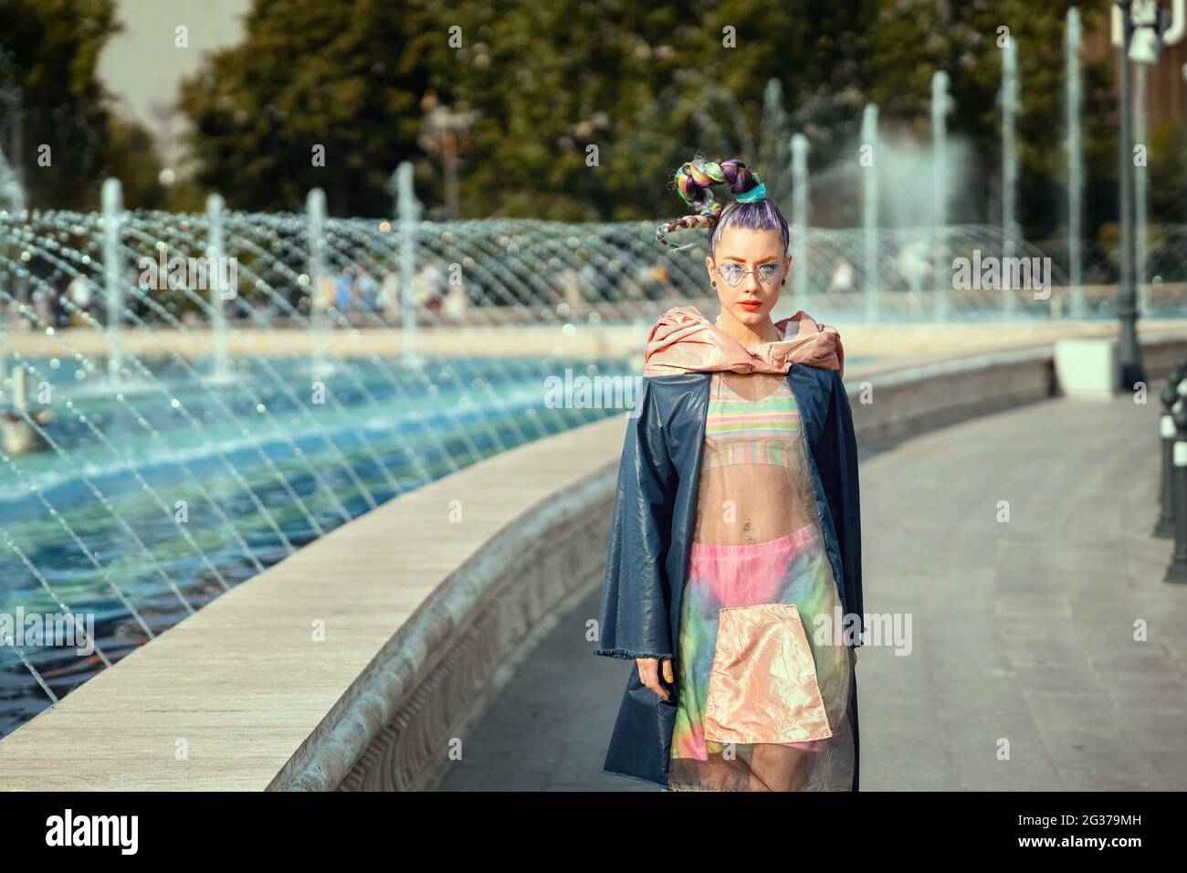 Nachhaltiges Modekonzept mit einem jungen Hipster-Mädchen, das auf der Straße der Stadt unterwegs ist und recycelte Kleidung mit trendigem Avantgarde-Pop-Look und -Stil trägt Stockfoto