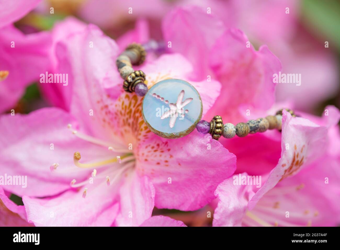 Armband mit Glasperlen auf blühender Blume Stockfoto
