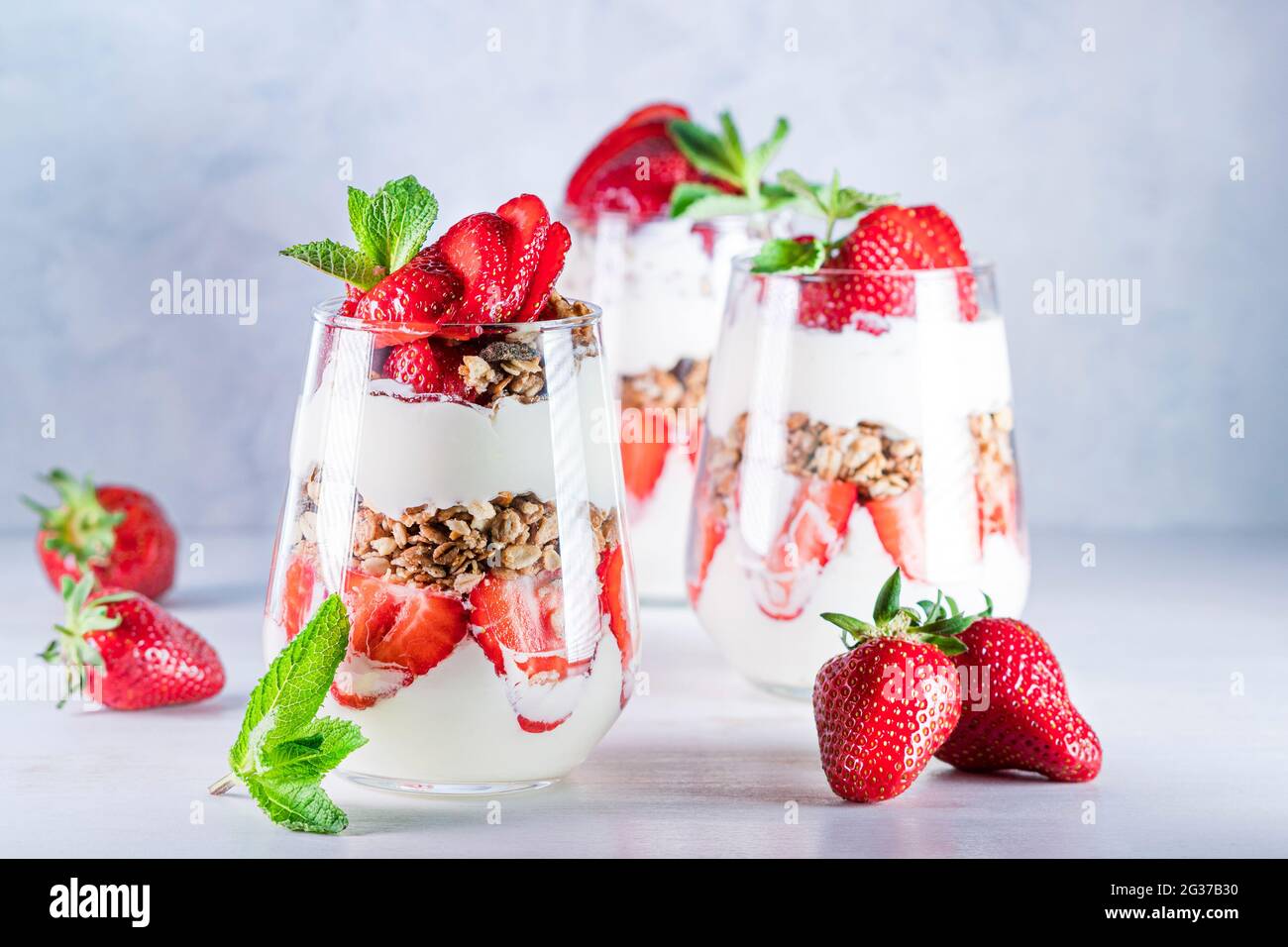 Gesundes Frühstück mit Erdbeerparfaits aus frischer Erdbeere, Joghurt und Müsli in Gläsern. Stockfoto