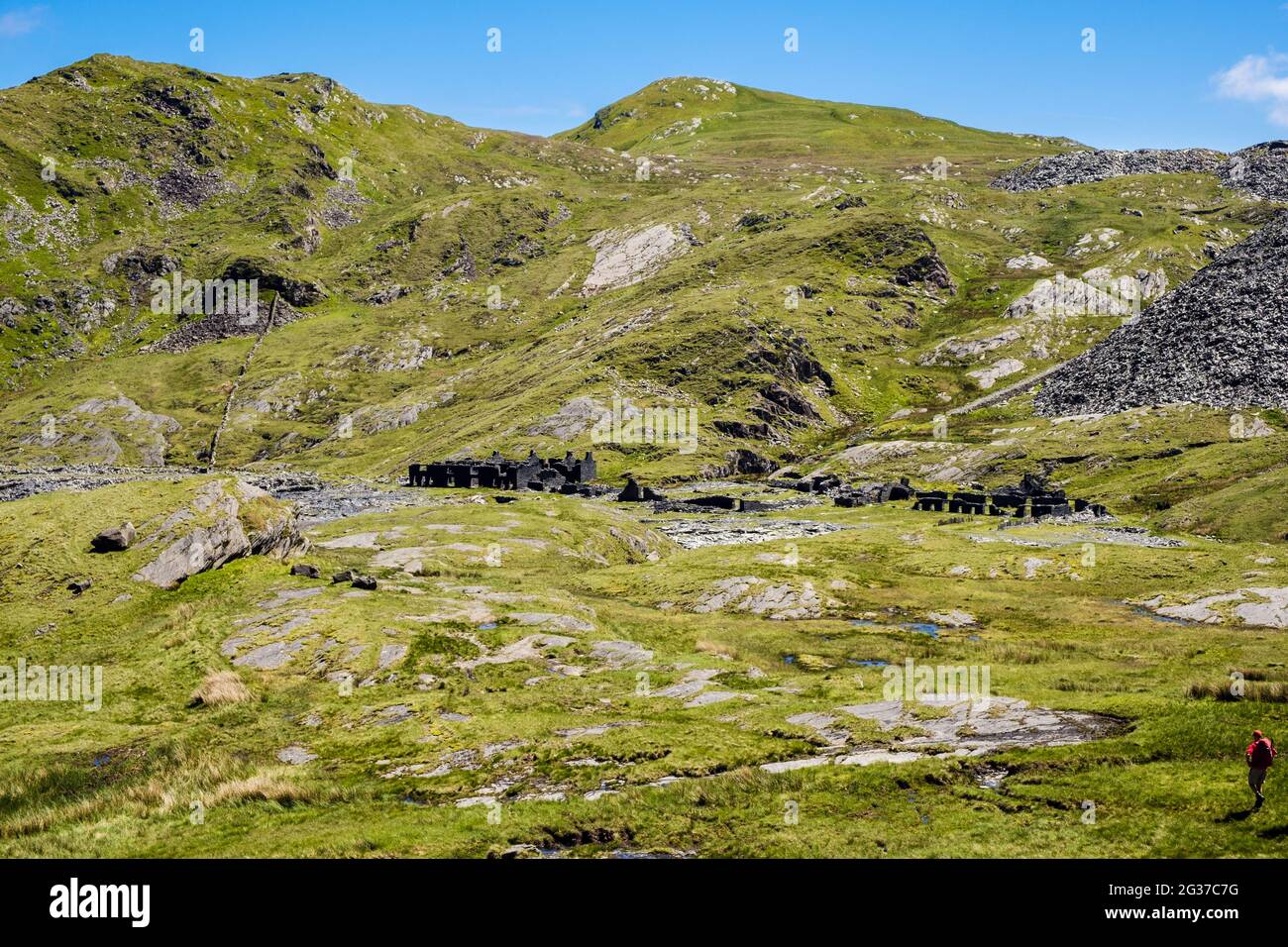 Wanderer nähert sich verfallenen Ruinen der Rhosydd Schiefersteinbruch Steinbruch Kaserne von Cnicht in Snowdonia. Croesor Bleanau Ffestiniog Gwynedd Wales Großbritannien Stockfoto