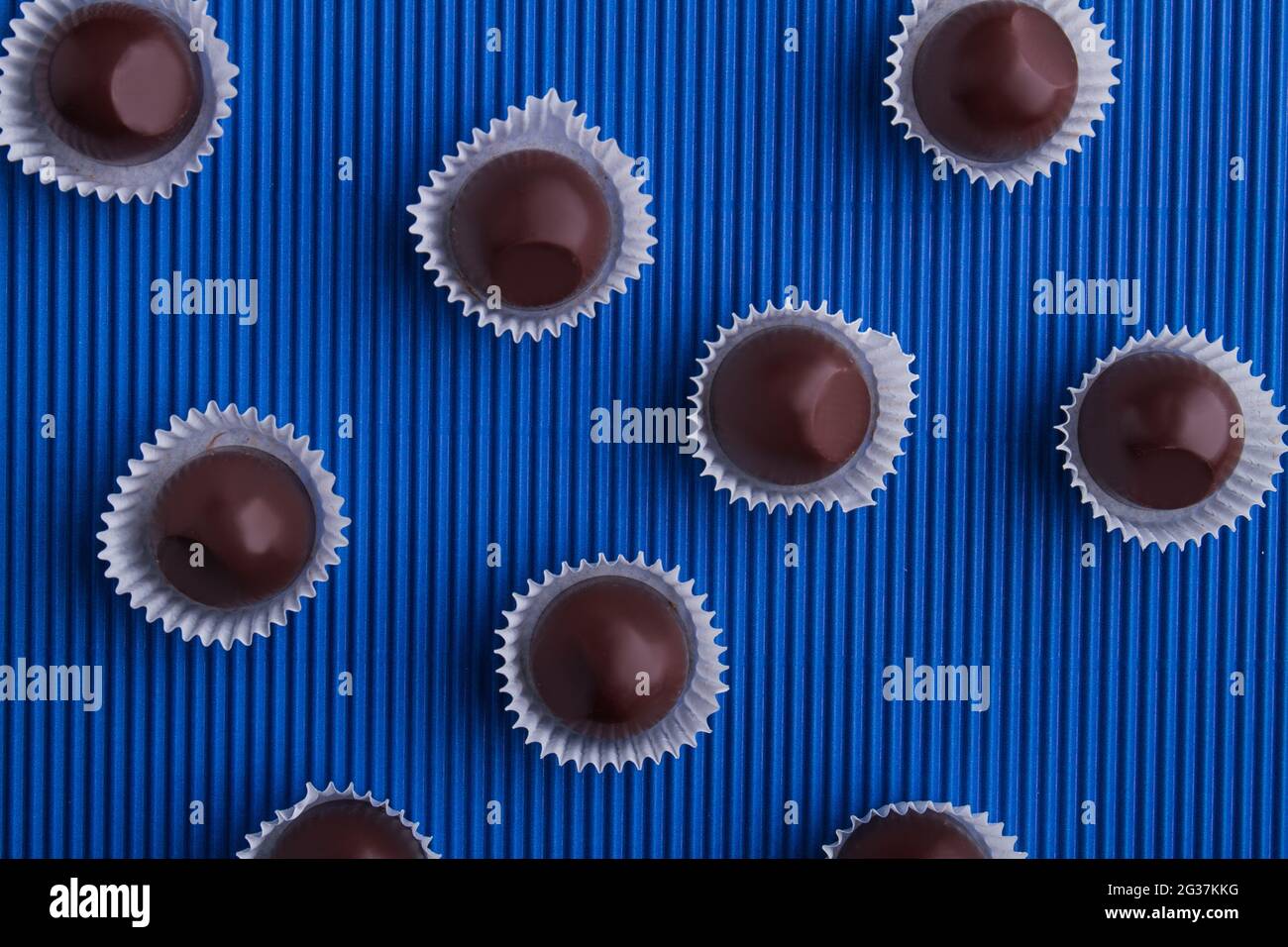 Draufsicht flach lagen runde braune Schokolade Bonbons auf blauem Hintergrund. Stockfoto