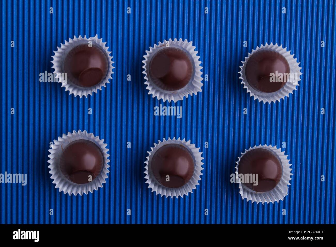 Set mit sechs braunen Schokoladen-Bonbons mit Verpackung. Stockfoto