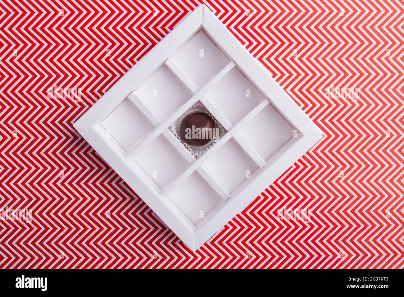 Quadratische Schokoladenbox mit einer einzigen Süßigkeit. Stockfoto