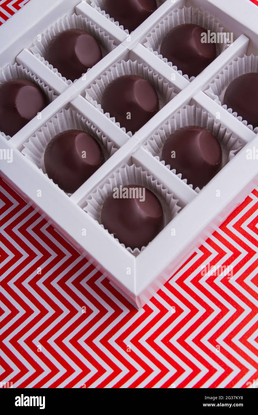 In der quadratischen Schachtel können Sie runde Schokoladen-Bonbons aus nächster Nähe sehen. Stockfoto