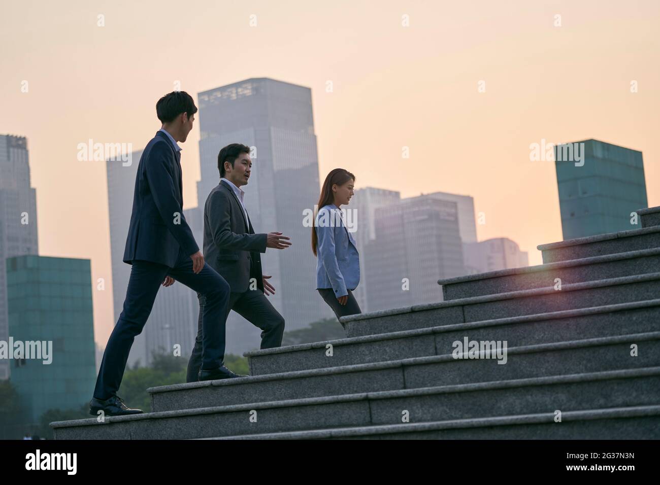 Team von drei asiatischen Führungskräften zu Fuß in der Innenstadt Finanzdistrikt Stockfoto