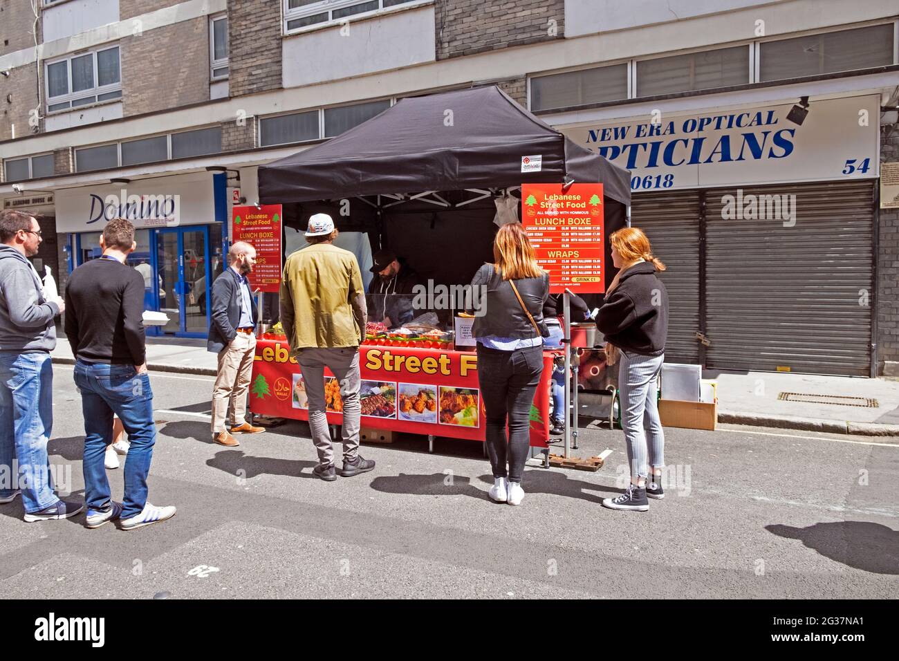 An einem Stand auf dem Londoner EC1 VON Leather Lane stehen Menschen für libanesisches Straßenessen AN Stockfoto