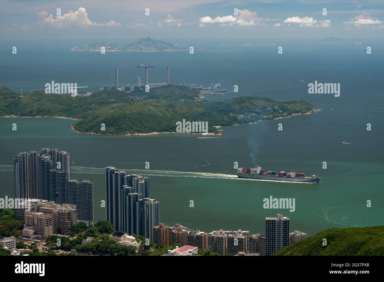 Ein Schiff im East Lamma Channel dampft an den luxuriösen Hochhäusern der Residence Bel-air in Pok Fu Lam auf Hong Kong Island vorbei Stockfoto