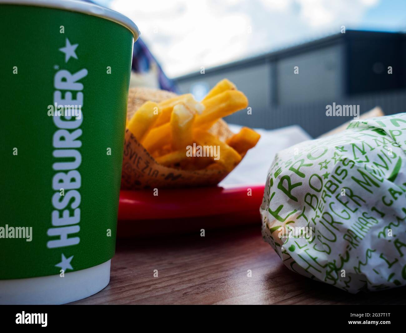 Pappbecher mit Hesburger Logo, Hamburger und Pommes Frites. Die finnische Restaurantkette Hesburger entwickelt sich in der Hauptstadtregion der Ukraine aktiv weiter. Von den fünfhundert Restaurants dieser Kette sind sieben in Kiew und der Region tätig. Stockfoto