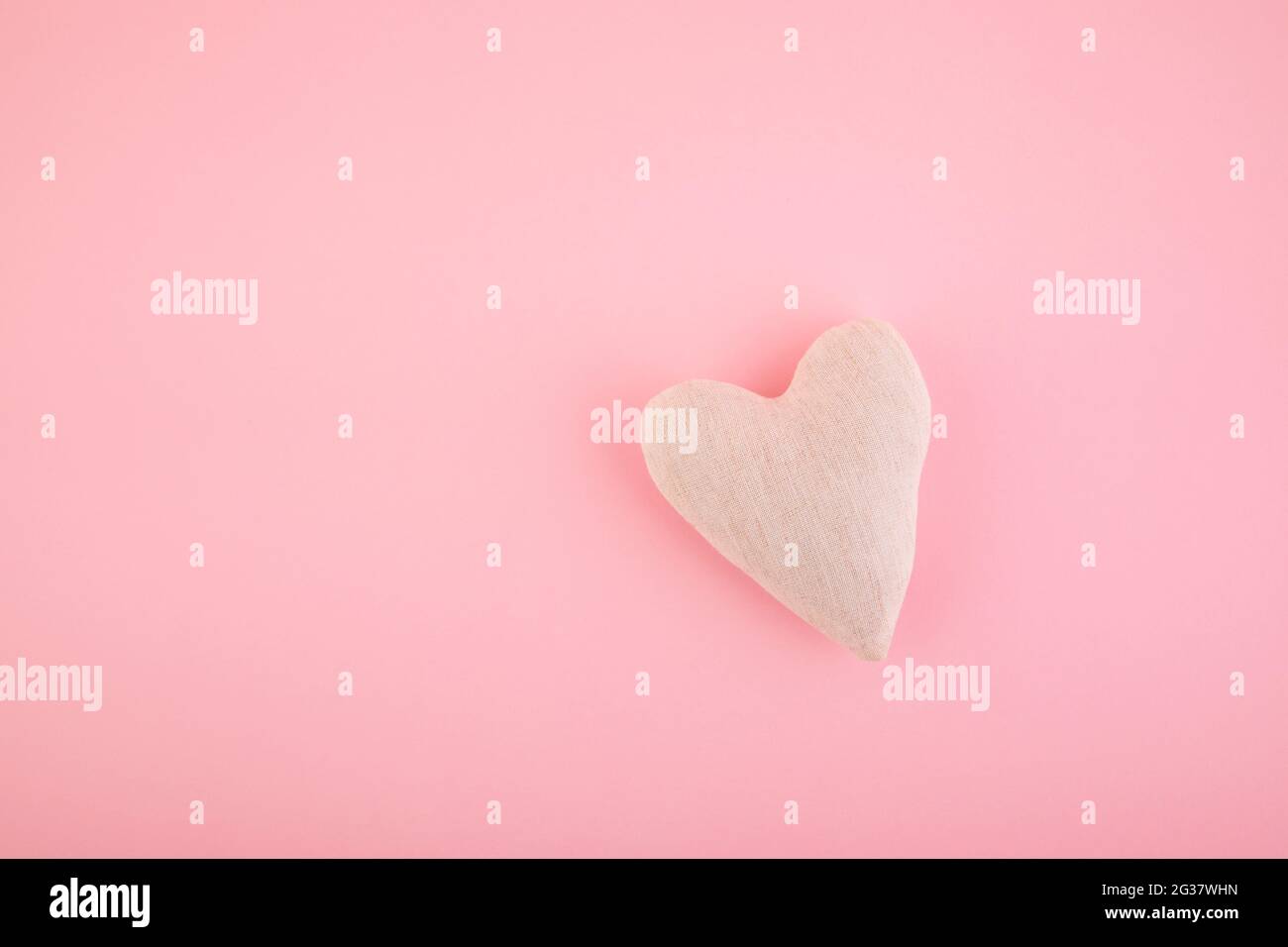 Kleines weißes Herz auf rosa Hintergrund Stockfoto