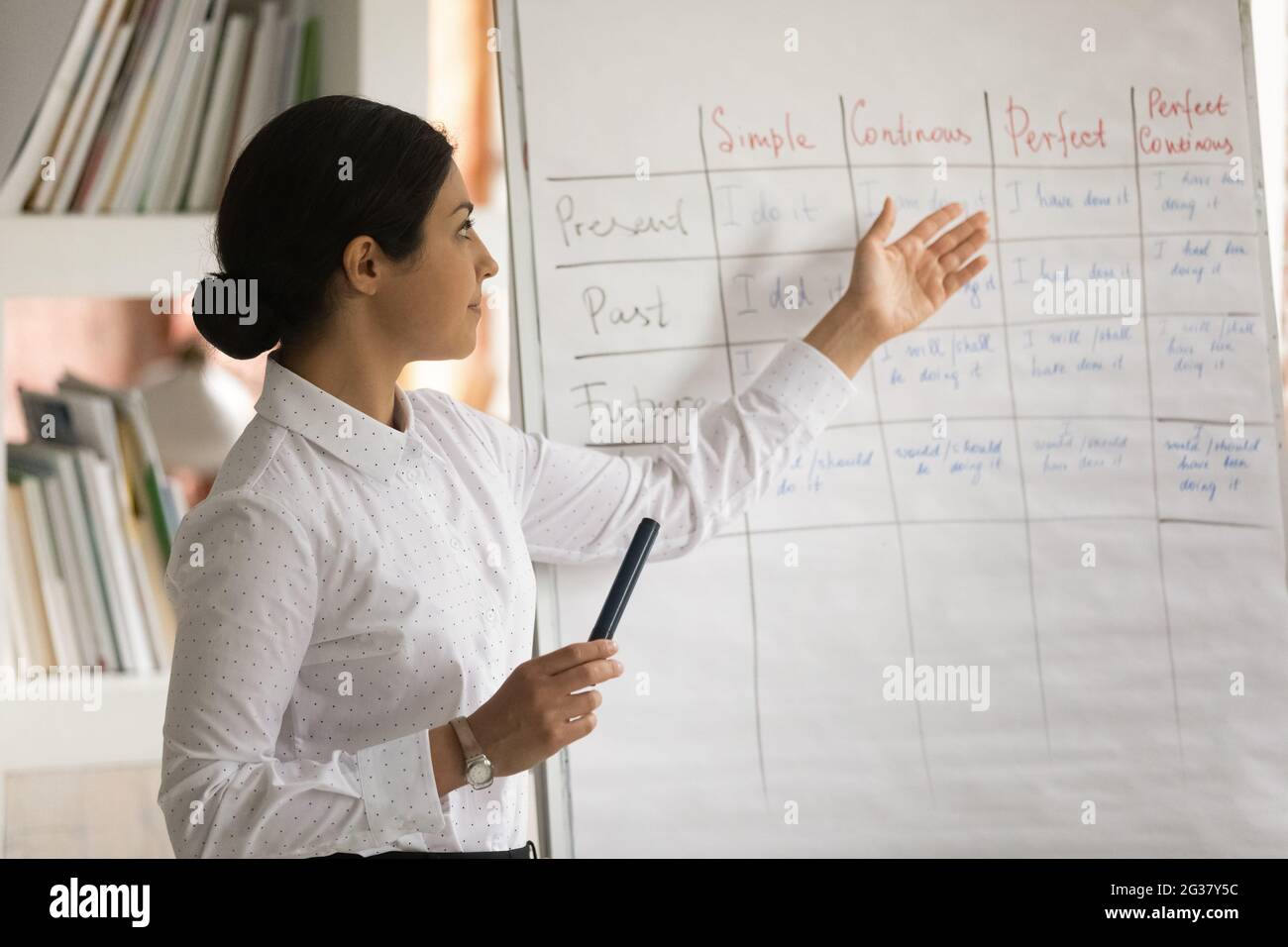 Fokussierte junge indische Ethnie weibliche Tutorin geben pädagogische Vorlesung. Stockfoto