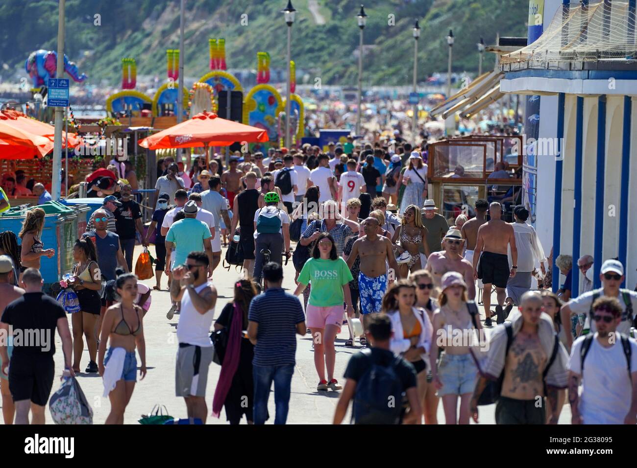 Die Menschen gehen auf der Promenade in Bournemouth, wenn das heiße Wetter anhält, und Prognostiker warnen vor dem Risiko von Gewitterschauern gegen Ende der Woche. Stockfoto