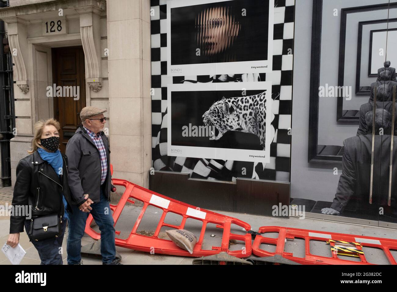 Straßenszene auf der Bond Street am 25. Mai 2021 in London, Großbritannien. Diese High-End-Marken sind nebeneinander auf einer sehr gewöhnlichen Wand zu sehen. Die Bond Street ist eine der Hauptstraßen im Einkaufsviertel West End und sehr nobly. Seit dem 18. Jahrhundert ist es eine modische Einkaufsstraße. Die reichen und wohlhabenden Shop hier vor allem für High-End-Mode und Schmuck. Stockfoto